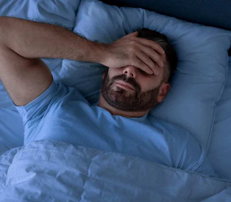 photo of a tired man with his hand over his eyes